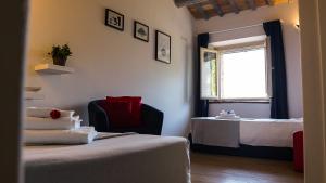 a room with two beds and a chair and a window at Casa Bartoccio - Casa vacanze in Fermignano