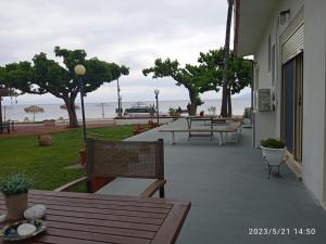 un patio con bancos y vistas al océano en Evoikos beach & resort, en Livanates