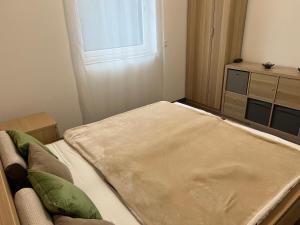 um pequeno quarto com uma cama e uma janela em Strand közeli Önálló Apartman em Balatonalmádi