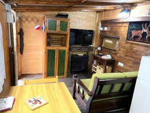 una sala da pranzo con tavolo e TV in una cabina di Chalet Sophia a Sestola