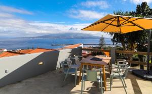 a patio with a table and an umbrella at Azores Haven Hill in Horta