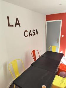uma mesa preta com cadeiras amarelas num quarto em La Casa - The Candy Cane em Amiens