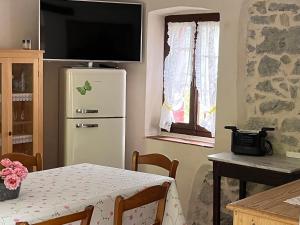 a kitchen with a table and a refrigerator and a window at ALTRAVISTA TARZO in Revine Lago
