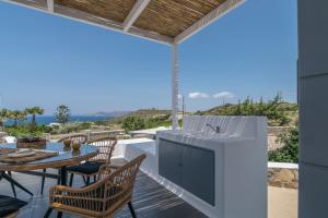 un patio con mesa, sillas y fregadero en Luna Blanca, en Adamas