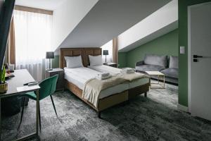 克拉科夫4Wings Apartments的一间卧室，配有一张床、一张书桌和一张沙发