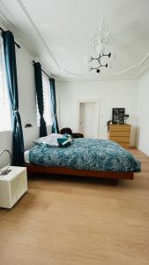 HochfeldenにあるCharmant appartement au coeur de Hochfeldenのベッドルーム1室(青い掛け布団付きのベッド1台付)