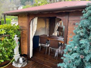 a wooden gazebo with a table and a dining room at Chalet Sophia in Sestola