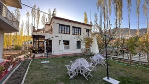 a house with two chairs and an umbrella in the yard at mandarava homestay in Leh