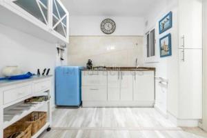 cocina con armarios blancos y nevera azul en Stunning apartment at beach en Caldes d'Estrac