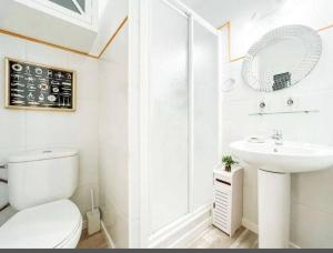 Baño blanco con aseo y lavamanos en Stunning apartment at beach en Caldes d'Estrac