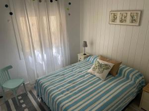 a bedroom with a bed with a blue and white striped blanket at Stunning apartment at beach in Caldes d'Estrac