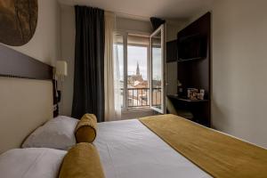 a hotel room with a teddy bear laying on a bed at Brit Hotel Europ Bergerac in Bergerac