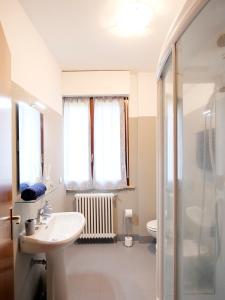 ein weißes Bad mit einem Waschbecken und einer Dusche in der Unterkunft [house in color] in SantʼAntonio