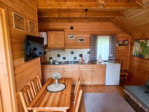 een keuken en eetkamer met een tafel in een huisje bij Domki Pod Horbem in Polańczyk