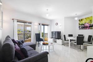 a living room with a couch and a table at Flat with Pool Marina and Sea View in Albufeira
