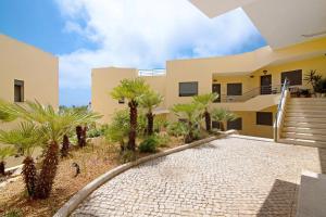 a house with palm trees in front of it at Flat with Pool Marina and Sea View in Albufeira