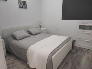 Habitación blanca con cama y TV en Casa el campo, en La Frontera