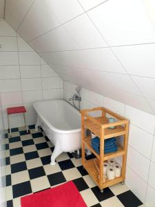 a bath tub in a bathroom with a checkered floor at Egen ovanvåning i charmig villa nära havet in Ystad