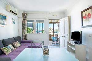 a living room with a purple couch and a tv at Casa Vistas al Mar Bolonia 2 in Tarifa