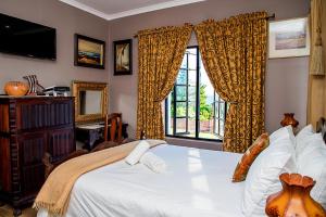 een slaapkamer met een groot bed en een raam bij aHa Guest House in Sea View