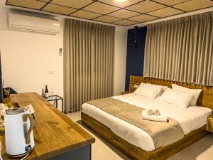 Un dormitorio con una cama y una mesa con una toalla. en Goland Hotel, en Mas'ada