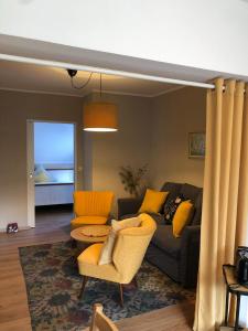 ein Wohnzimmer mit einem Sofa, Stühlen und einem Tisch in der Unterkunft Auszeit am Eifelsteig in Daun