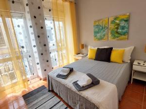 1 dormitorio con cama y ventana grande en Casa Olhão Terraço: espaço, conforto e terraço com churrasqueira, en Olhão