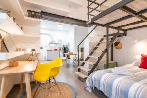 1 dormitorio con 1 cama y escritorio con silla amarilla en Super Mario Sea House, en Livorno
