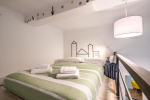 a bedroom with a large bed with green and white sheets at Super Mario Sea House in Livorno