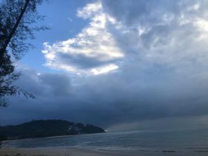 a cloudy sky over a beach and the ocean at Ruma in Cherating