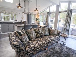 Una sala de estar con un sofá y una cocina. en Ewe Crag Beck Lodge, en Whitby