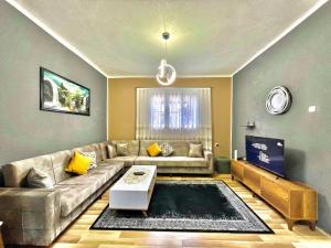 een woonkamer met een bank en een tafel bij Apartment-Rubin in Pristina