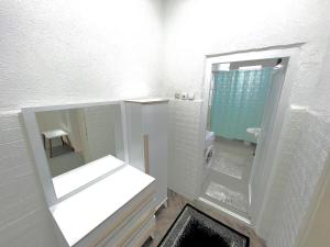 een witte badkamer met een wastafel en een spiegel bij Apartment-Rubin in Pristina