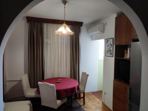 une salle à manger avec une table rouge et des chaises blanches dans l'établissement Elpa, à Belgrade
