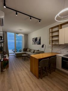 een keuken en een woonkamer met een tafel en een bank bij Sapphire Residence Green Coast in Palasë