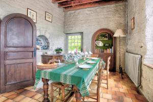 uma cozinha com uma mesa com uma toalha de mesa verde em La Grangerie - Charmante demeure typique em Erquy