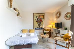 a small room with a bed and a television at Alienor - Charmant appartement plein coeur dArcachon in Arcachon