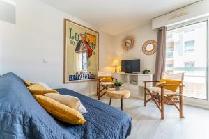 a bedroom with a blue bed and a television at Alienor - Charmant appartement plein coeur dArcachon in Arcachon +6 photos