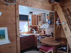 eine Küche mit Holzschränken und einem Tisch in einer Hütte in der Unterkunft Kabyssen Torsö Mariestad in Vilsten