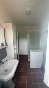 uma casa de banho com um lavatório, um chuveiro e um WC. em LE CHANT DES OISEAUX arrivée autonome em Sorbais