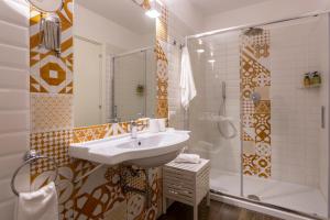 ein Bad mit einem Waschbecken und einer Dusche in der Unterkunft Eleonora Suites in Neapel