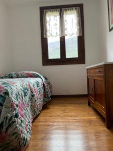 1 dormitorio con cama, ventana y suelo de madera en ALTRAVISTA TARZO en Revine Lago