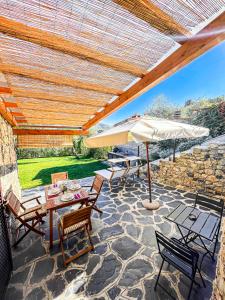 un patio con tavoli, ombrellone e sedie di I Particolari a Lerici