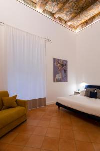 ein Schlafzimmer mit einem Bett und einem Sofa darin in der Unterkunft Eleonora Suites in Neapel