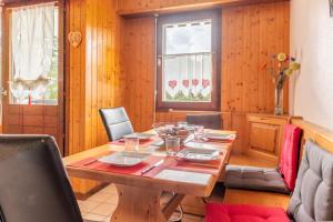 uma sala de jantar com uma mesa de madeira e cadeiras em Cosy Criou - Appartement avec vue sur la montagne em Samoëns