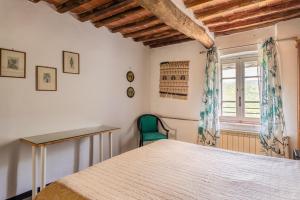 1 dormitorio con cama, escritorio y ventana en Abbacca-là appartamento 1, en Lucca