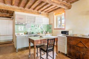 una cucina con un tavolo di legno e un bancone di Abbacca-là appartamento 2 a Lucca