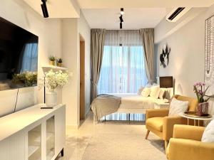 ein Hotelzimmer mit einem Bett und einem Wohnzimmer in der Unterkunft the Luxe by infinitum suites in Kuala Lumpur