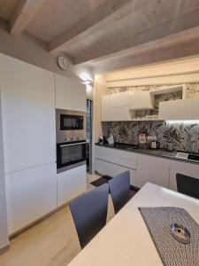 una cucina con armadi bianchi, tavolo e sedie di I Particolari a Lerici