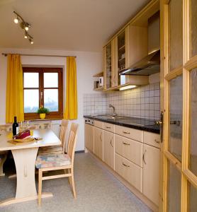 cocina con mesa, cortinas amarillas, mesa y sillas en Moarhof Gufidaun en Chiusa